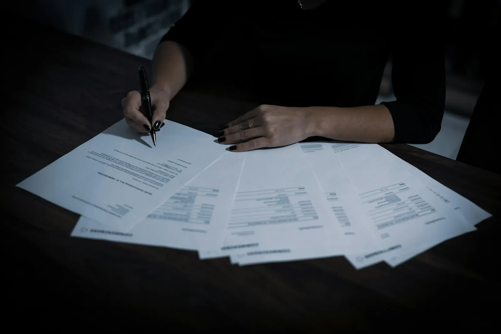 Business person reviewing competing contract offers at desk