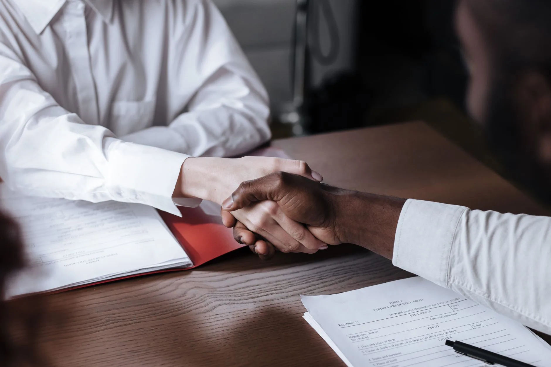 Business owners shaking hands after signing a seller-financed acquisition deal