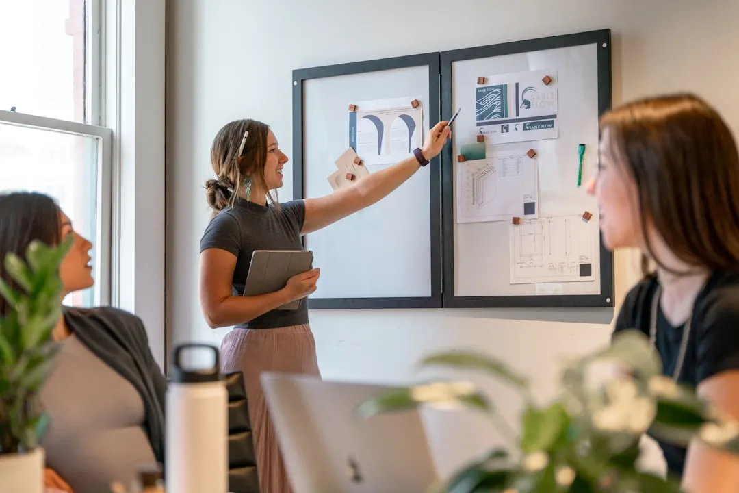 Small business team gathered around a whiteboard for a morning huddle meeting