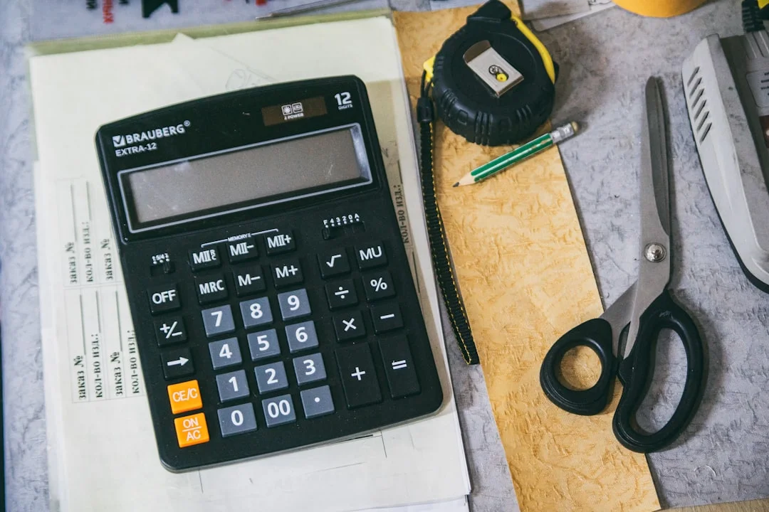 Business owner reviewing financial documents with calculator, stressed about cash flow