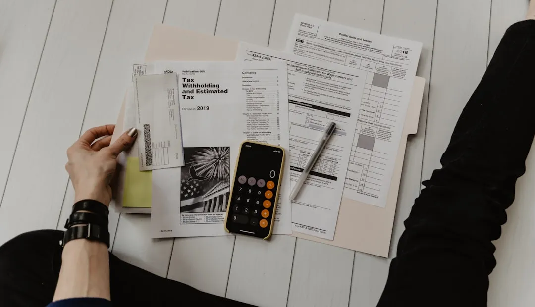 Person studying financial loan paperwork at a desk with a calculator